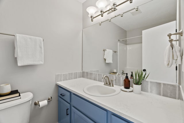 bathroom with walk in shower, vanity, and toilet