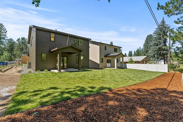 rear view of property featuring a patio and a lawn