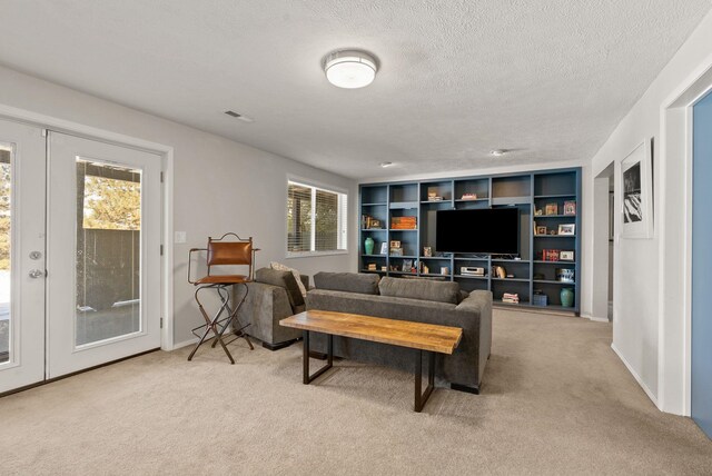 living room with light carpet, a textured ceiling, and french doors