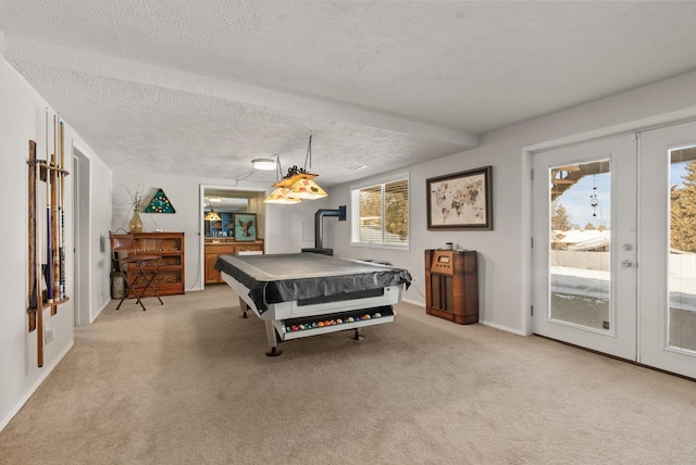 game room with a wood stove, light carpet, a textured ceiling, and french doors