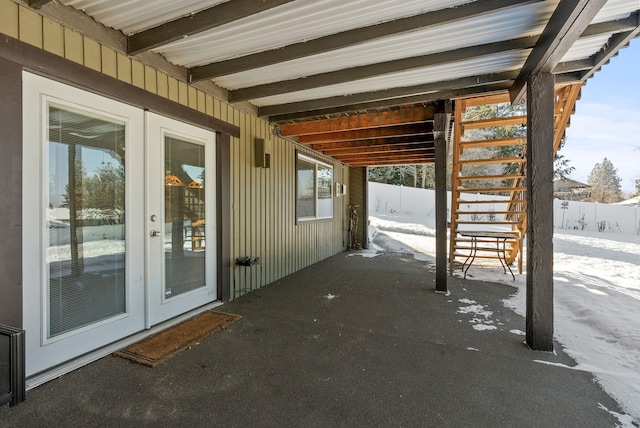 snow covered patio featuring french doors