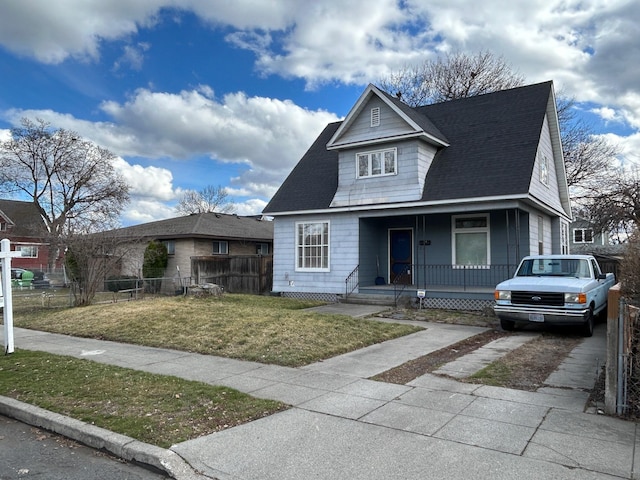 bungalow-style home featuring a front yard, fence, covered porch, a shingled roof, and concrete driveway