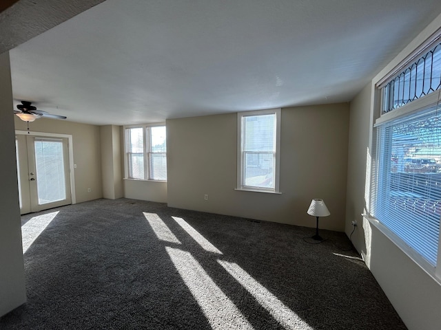 carpeted empty room with a ceiling fan