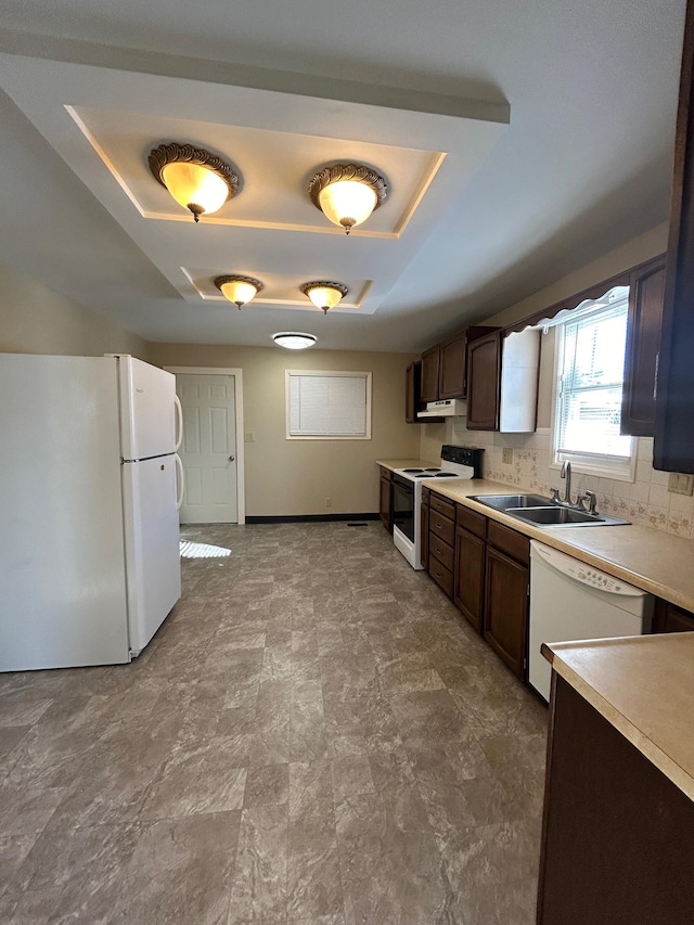 kitchen with white appliances, baseboards, a sink, light countertops, and dark brown cabinets