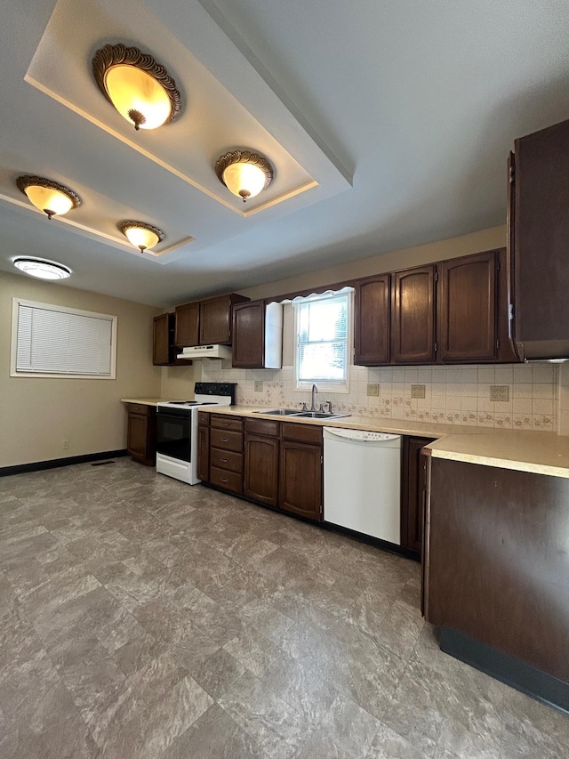 kitchen with under cabinet range hood, a tray ceiling, electric range oven, dark brown cabinets, and dishwasher