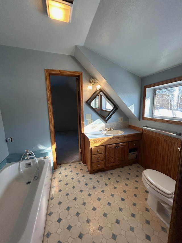 907 W Fairview Ave, Spokane, WA 99205 - bathroom featuring vanity, toilet, tile patterned floors, a bath, and lofted ceiling