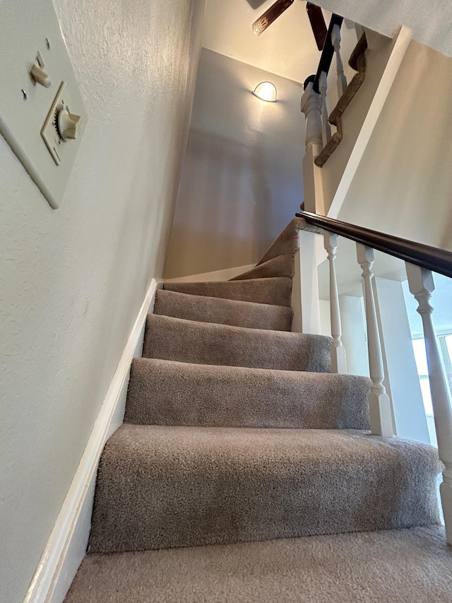 staircase featuring a textured wall