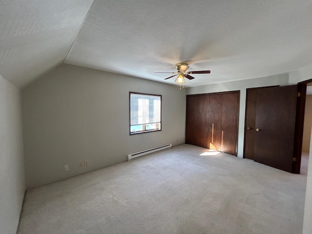 907 W Fairview Ave, Spokane, WA 99205 - unfurnished bedroom with a baseboard heating unit, light carpet, multiple closets, ceiling fan, and lofted ceiling