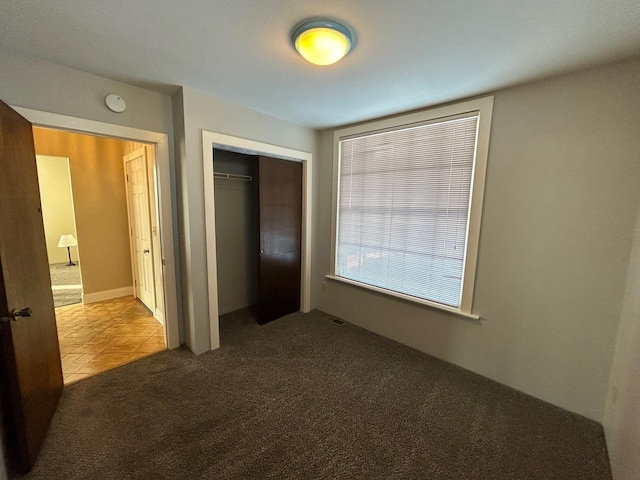 907 W Fairview Ave, Spokane, WA 99205 - unfurnished bedroom with carpet flooring, a closet, and tile patterned floors