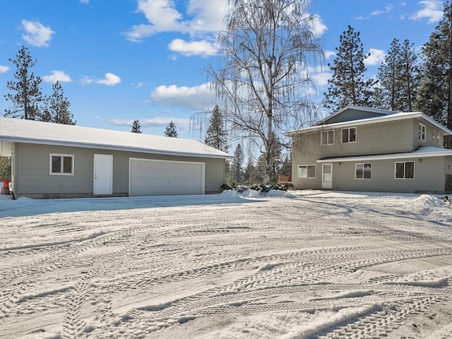 view of snowy exterior featuring a garage