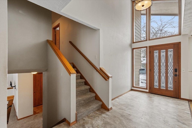 entrance foyer with stairs and baseboards