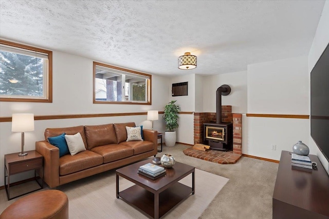 living area with baseboards, a textured ceiling, and a wood stove