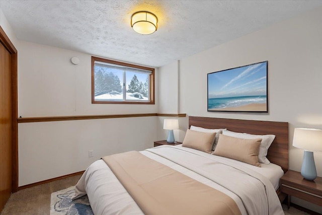 carpeted bedroom with baseboards and a textured ceiling