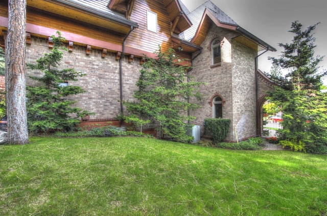 view of side of home featuring central air condition unit and a lawn