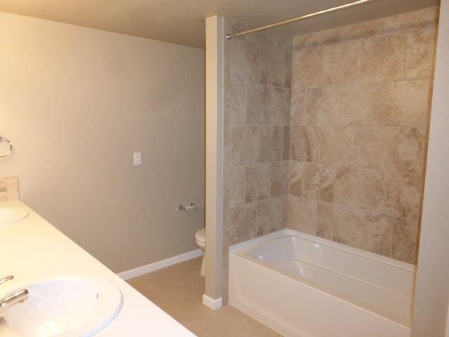 full bathroom with tiled shower / bath combo, vanity, and toilet