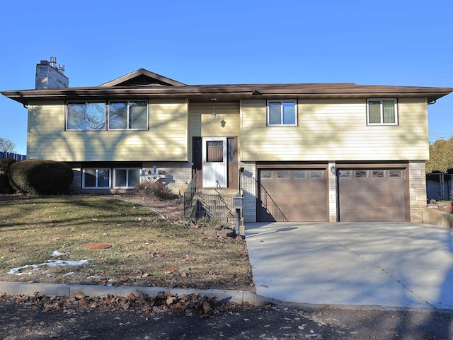 bi-level home featuring a garage and a front lawn