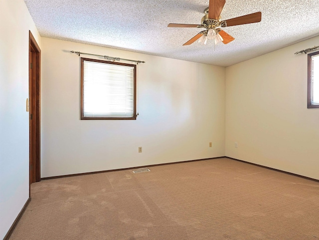 carpeted empty room featuring ceiling fan and a textured ceiling