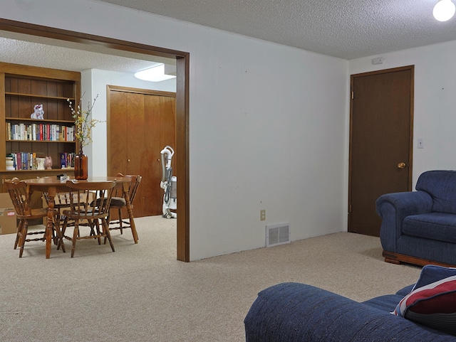 carpeted living room featuring a textured ceiling