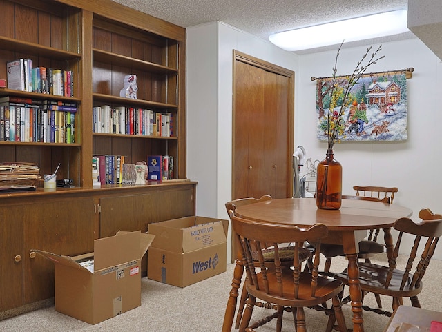 dining room with light carpet and a textured ceiling