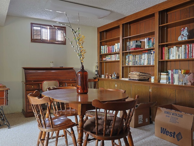 dining area featuring light carpet and a textured ceiling