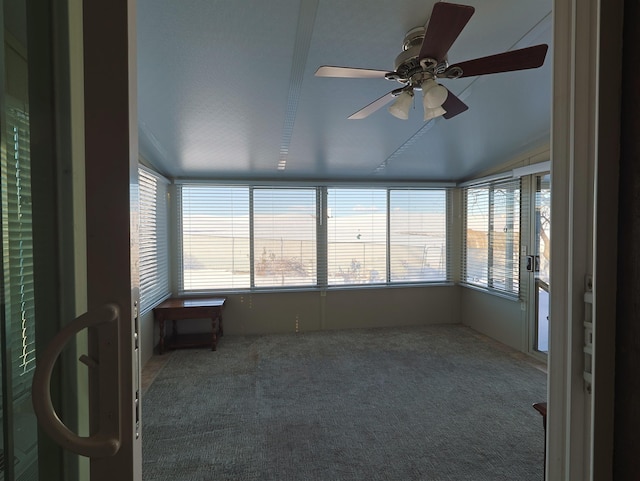 unfurnished sunroom featuring ceiling fan and a healthy amount of sunlight