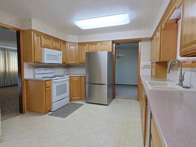 kitchen with sink, white appliances, and backsplash