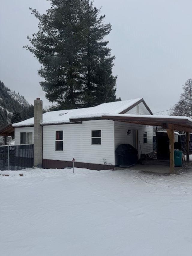 view of snowy exterior featuring a carport