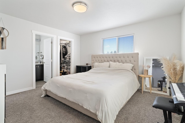 bedroom with a closet, connected bathroom, a spacious closet, and carpet