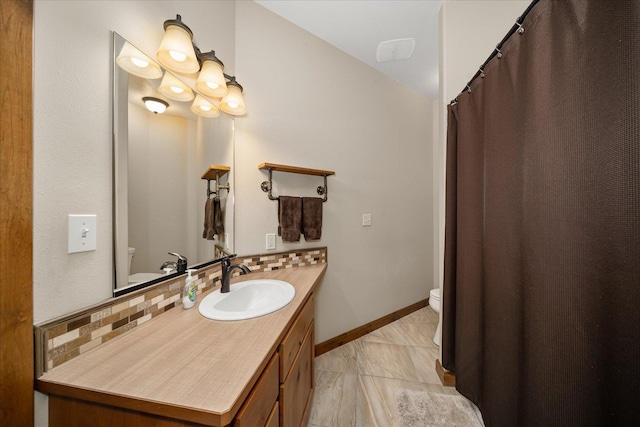 bathroom with tasteful backsplash, vanity, and toilet