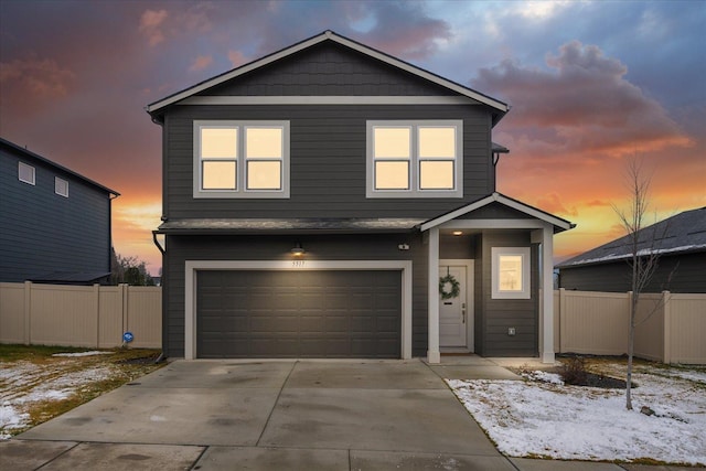 traditional-style house with concrete driveway, fence, and an attached garage