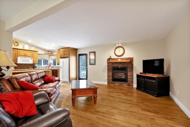 living room featuring vaulted ceiling and light hardwood / wood-style flooring