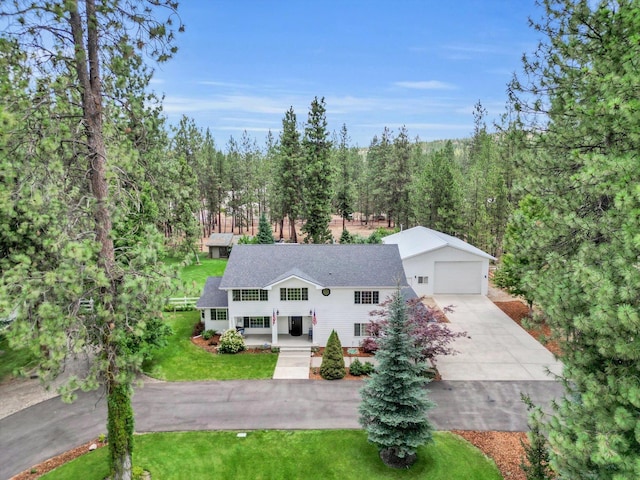 view of front of home featuring a porch, a garage, and a front lawn