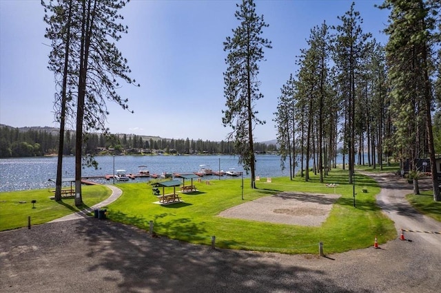 view of home's community with a lawn and a water view