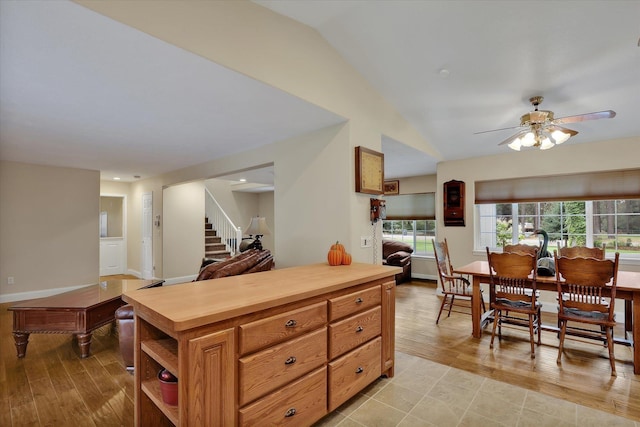 kitchen with butcher block countertops, vaulted ceiling, ceiling fan, and light wood-type flooring