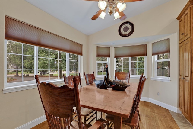 dining area with ceiling fan, vaulted ceiling, and light hardwood / wood-style flooring