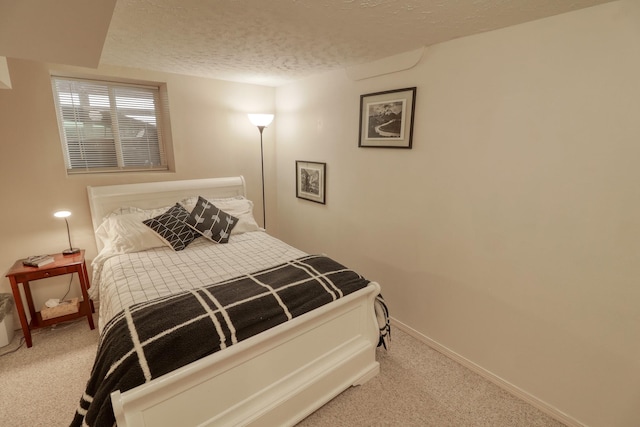 bedroom featuring light carpet and a textured ceiling