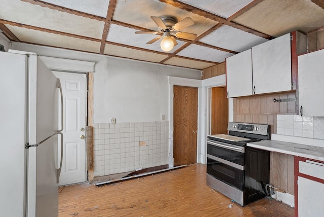 kitchen with coffered ceiling, stainless steel electric range oven, white fridge, light hardwood / wood-style floors, and white cabinets