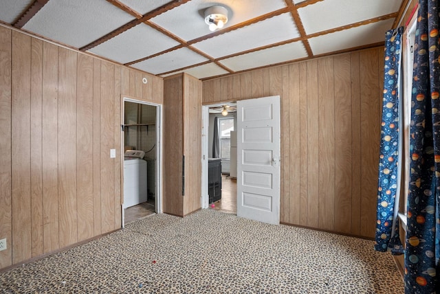 unfurnished bedroom with washer / clothes dryer, carpet, and wood walls