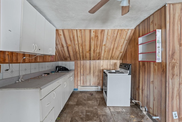 kitchen featuring washer / dryer, sink, wood walls, a baseboard radiator, and white cabinets