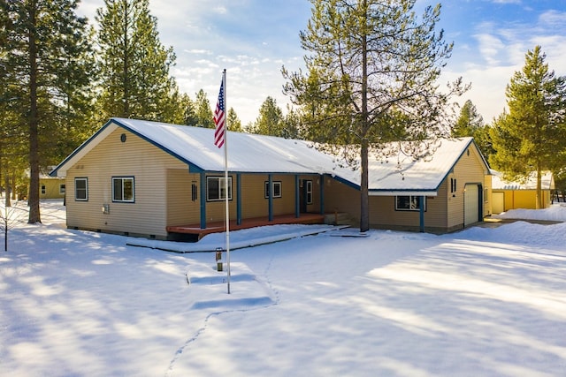 snow covered back of property with a porch