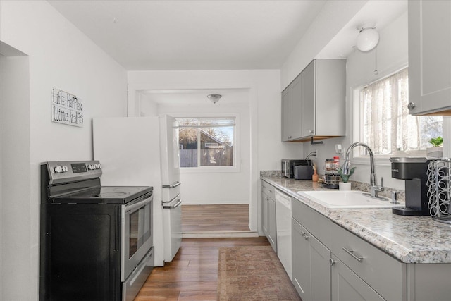 kitchen with sink, gray cabinetry, hardwood / wood-style flooring, electric range, and white dishwasher