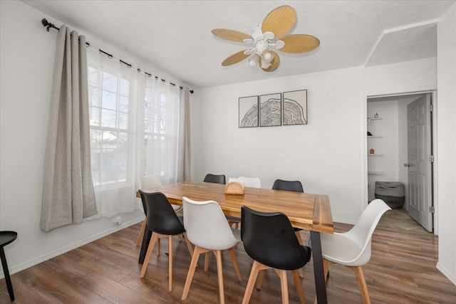 dining room featuring built in shelves, ceiling fan, and dark hardwood / wood-style flooring