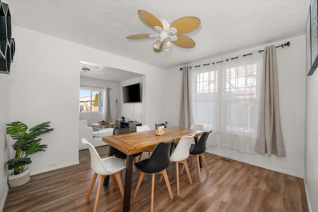 dining area featuring ceiling fan, a textured ceiling, and dark hardwood / wood-style flooring