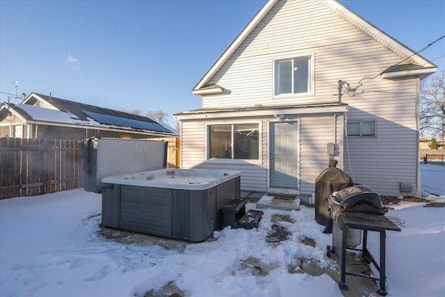 snow covered rear of property with a hot tub and central AC unit