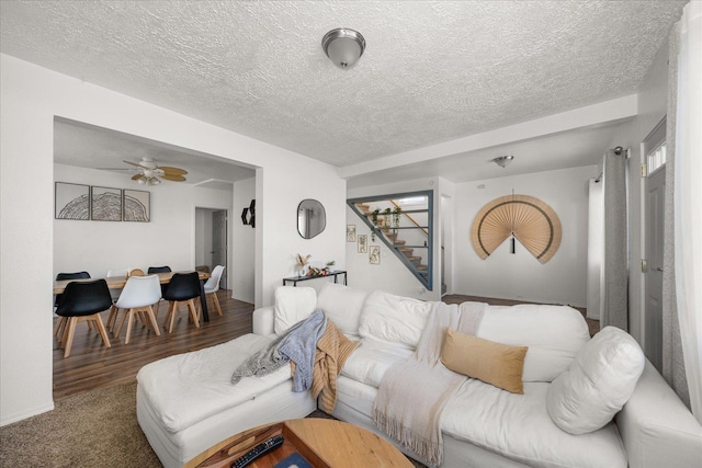 living room featuring ceiling fan, dark hardwood / wood-style flooring, and a textured ceiling