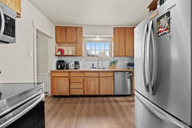 kitchen with sink, dark wood-type flooring, appliances with stainless steel finishes, and decorative backsplash