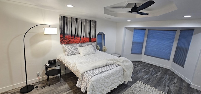 bedroom featuring dark wood-type flooring, ceiling fan, and a raised ceiling