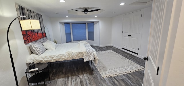 bedroom with a raised ceiling and dark hardwood / wood-style flooring