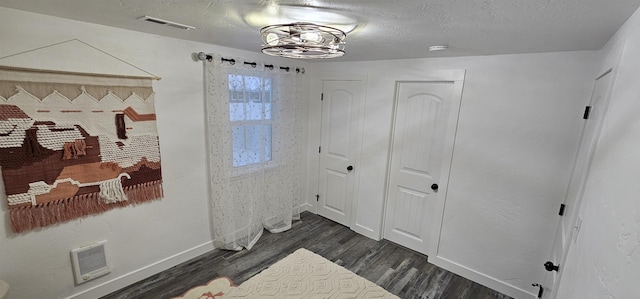 interior space featuring dark wood-type flooring and a textured ceiling