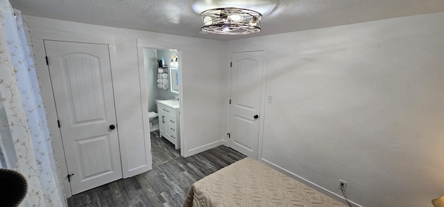 interior space featuring dark hardwood / wood-style floors, a textured ceiling, and ensuite bathroom